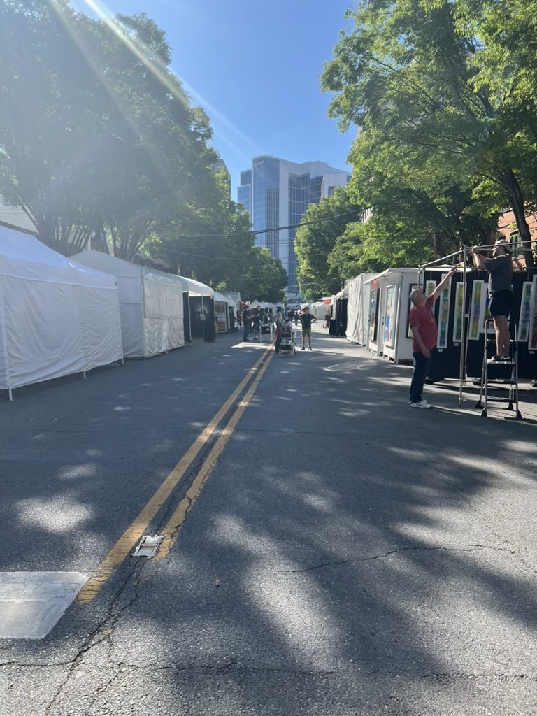 Downtown art fair street with vendor tents lined up on both sides