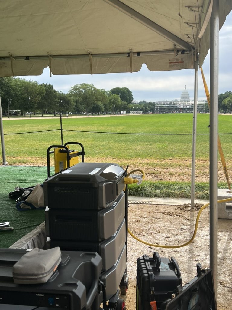 Battery stack and road cases set up beside an event tent on the Mall