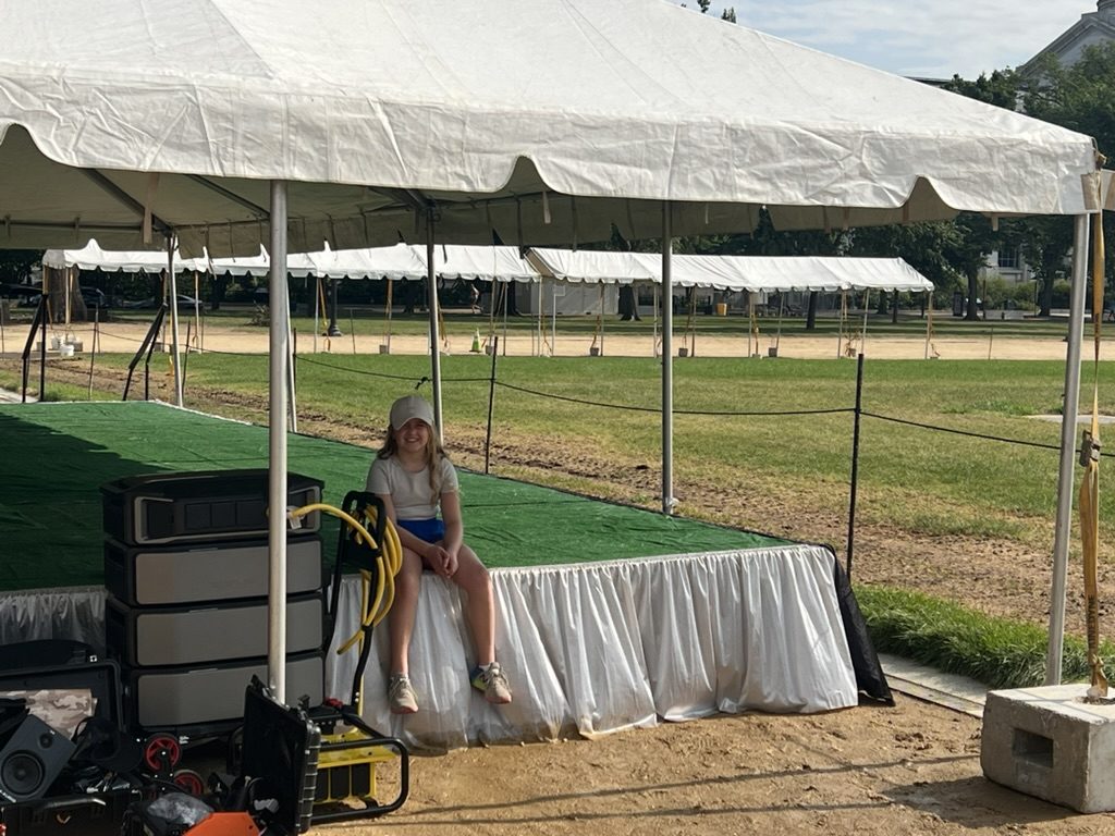 A family member sitting next to the EcoFlow rig at a recent event setup