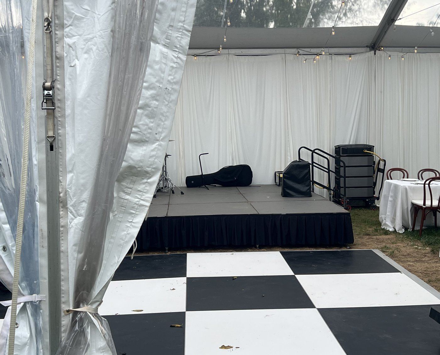 A tented reception at night, band and dance floor lit